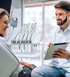 dentist reviewing information on tablet with patient