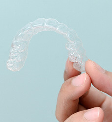 closeup of patient holding clear aligner