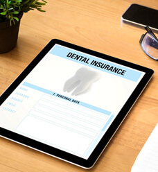 dental insurance form on tablet next to desk supplies