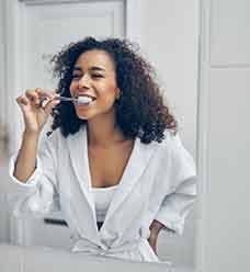 A dentist holding sample Invisalign over model teeth