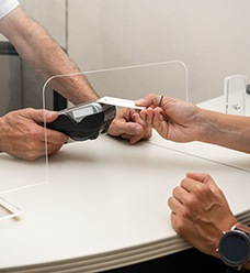 Patient using card to pay for treatment in dental clinic